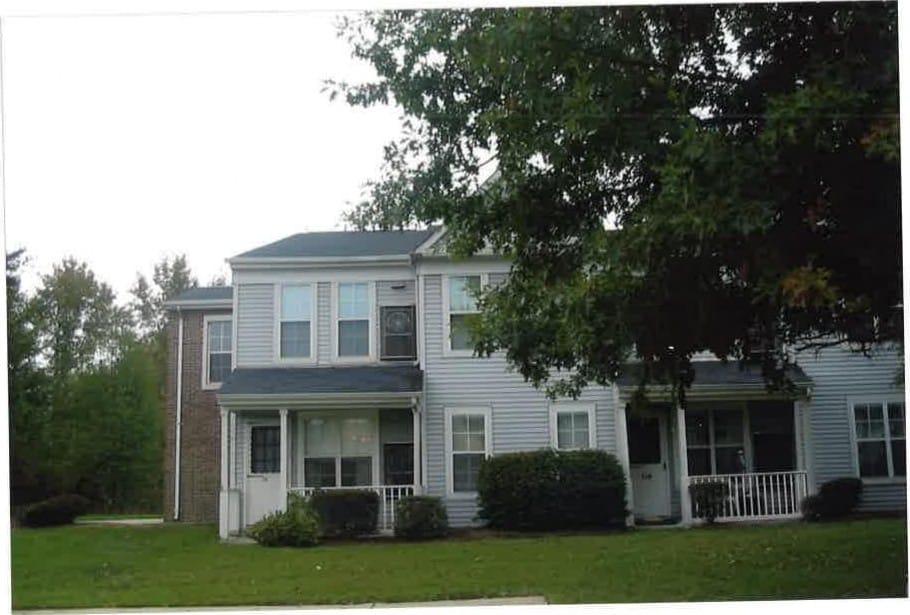 An end unit at Indian Head Elderly with a covered porch, framed by a large shade tree